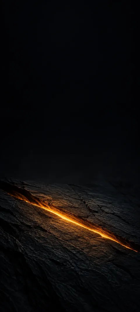 Glowing diagonal amber fissure in rough black slate beneath a dark empty field.