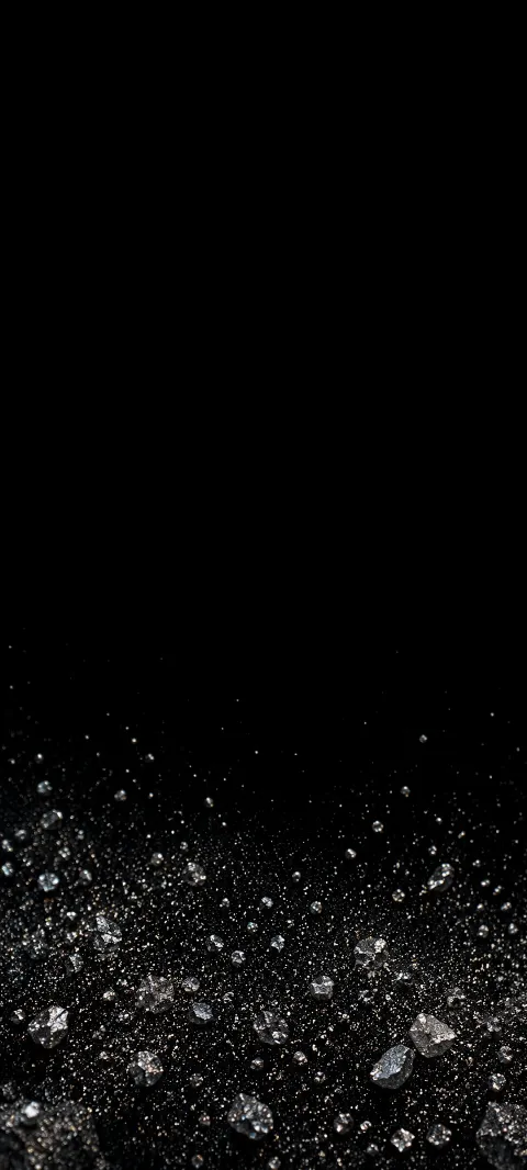 Silver mineral fragments scattered at the bottom of a black background.
