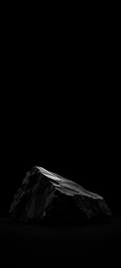 A low black stone wedge with a silver-lit sloping surface against black.