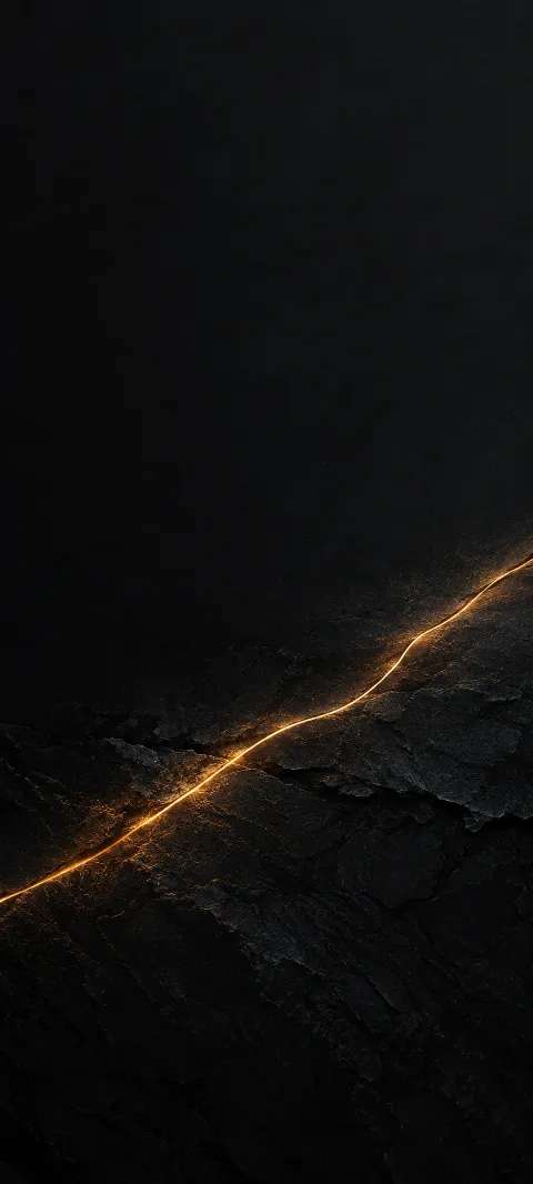 Thin glowing amber seam crossing dark textured slate diagonally.