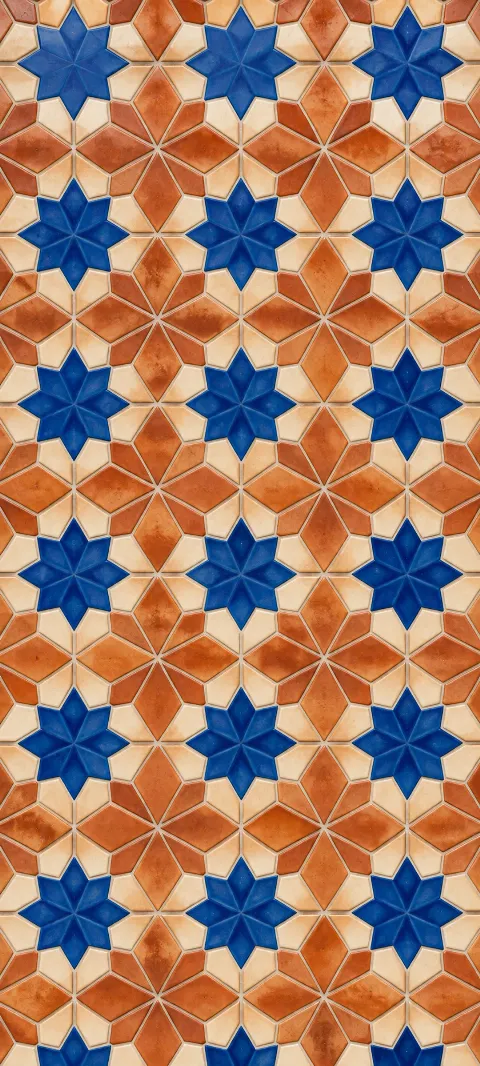 Cobalt star shapes repeat across warm terracotta ceramic.