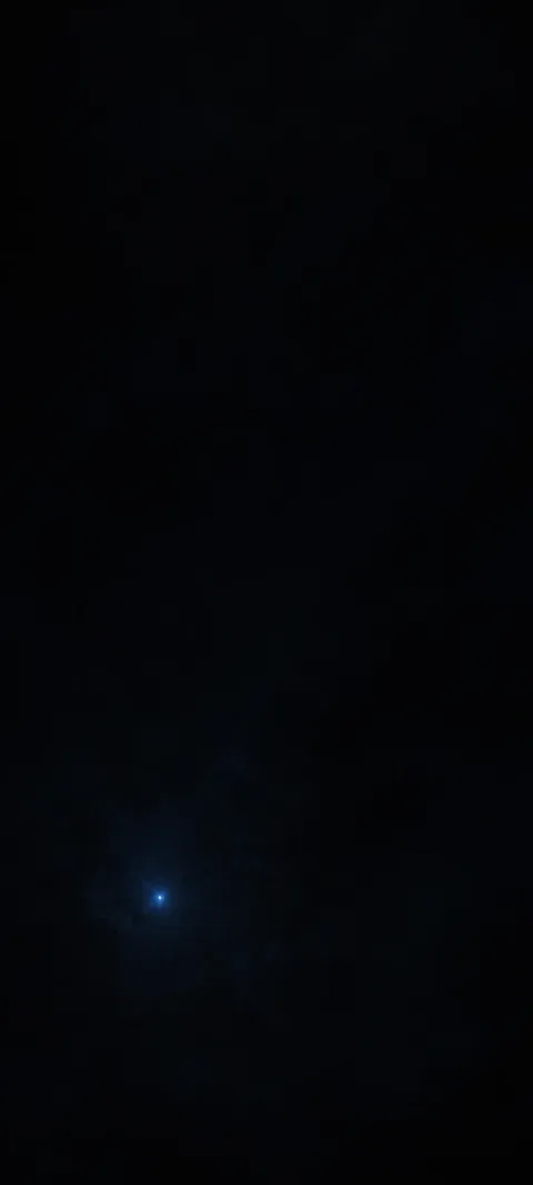 Tiny blue light near the lower left in a nearly black field.
