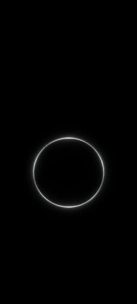 A complete thin dim silver circle floating against black.