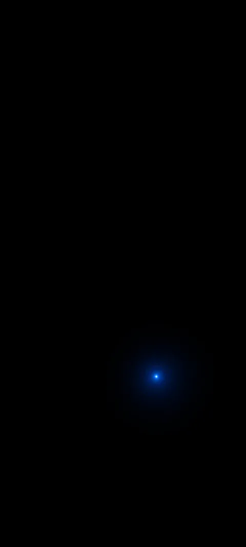 A tiny blue-white point and soft blue halo low in a black field.