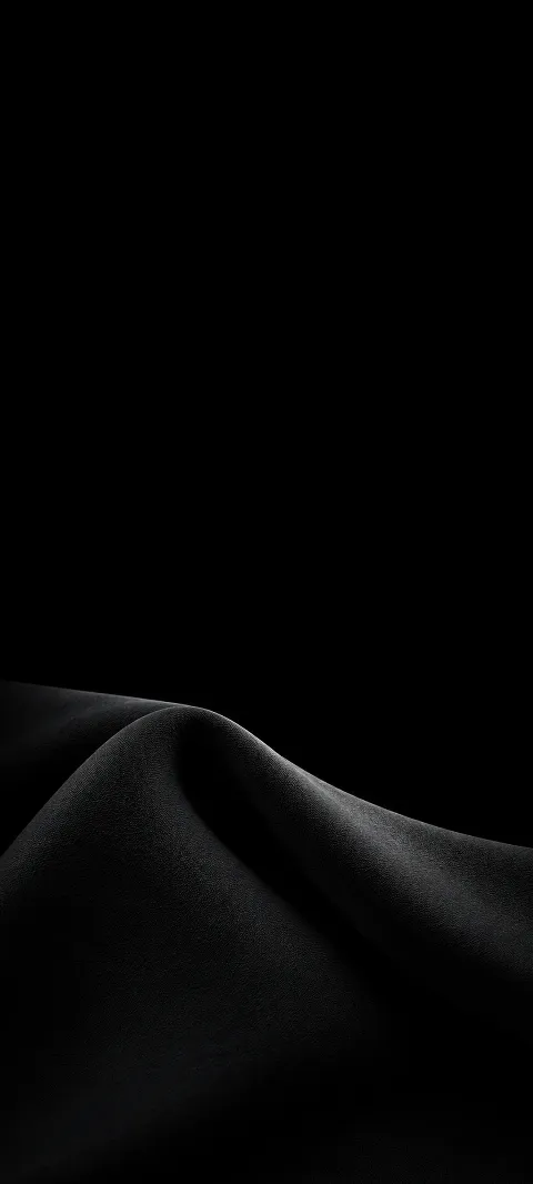 A softly lit charcoal fabric fold below a broad black field.
