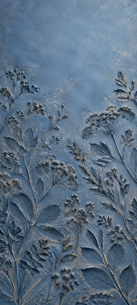 Blue clay holds repeating raised botanical leaf and flower impressions.