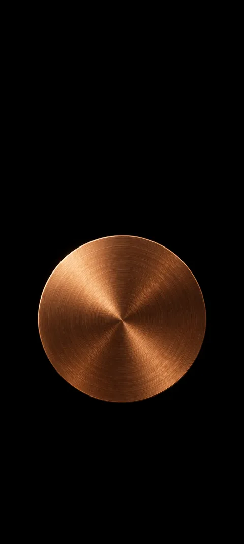 A round brushed copper disc with concentric texture on a black background.