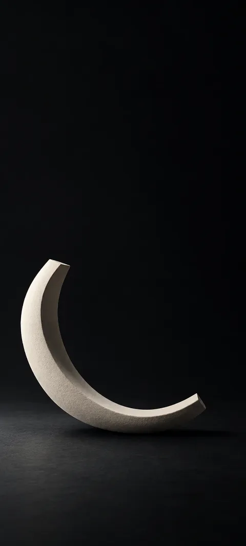 Open ivory ceramic arc on a dark graphite floor.