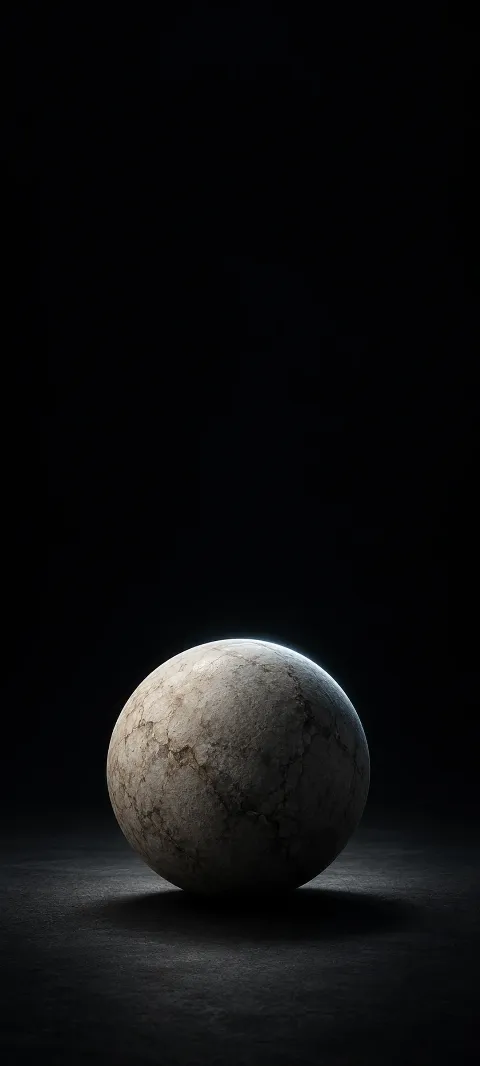 An ivory stone sphere on a matte black surface with a cool rim light.