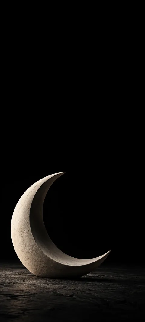 Matte ivory crescent sculpture standing on a dim textured surface against black space.