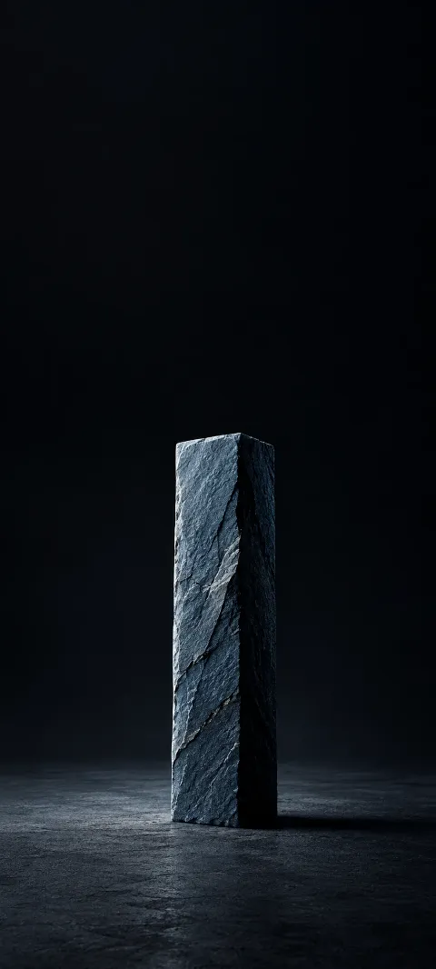 Blue gray rectangular slate pillar on dark ground with edge light.