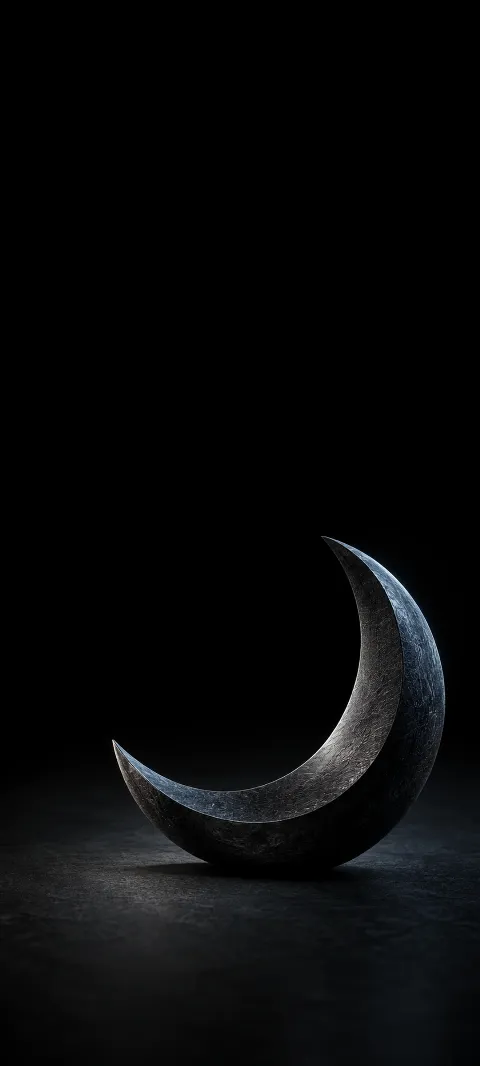 A graphite crescent sculpture with cool rim light on a black plane.