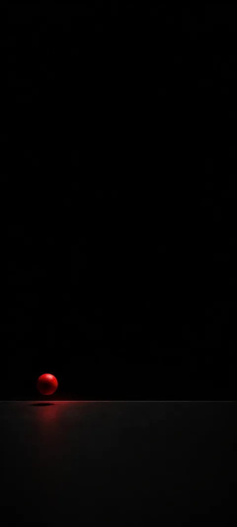 A small ruby sphere hovering above a faint seam on a black plane.