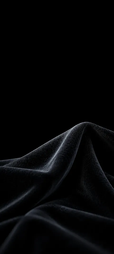 A cool-lit charcoal velvet fold rises against a black background.