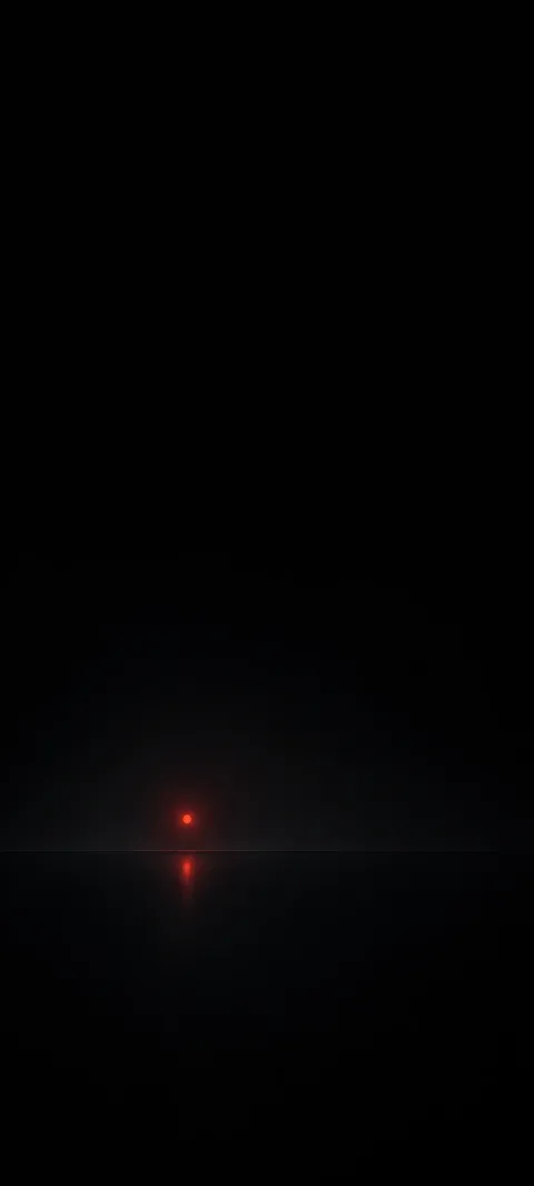 A tiny red light reflects below a faint horizon in black space.