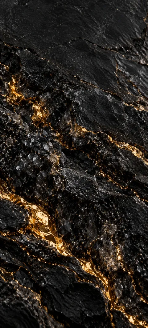 Black mineral grain is crossed by narrow molten-gold seams.