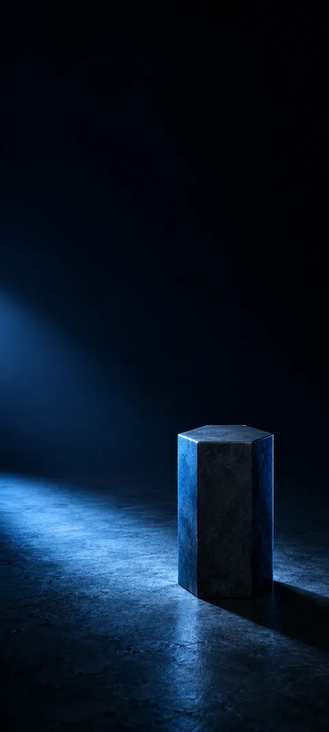 Dark hexagonal pillar lit by a blue light on a black floor.