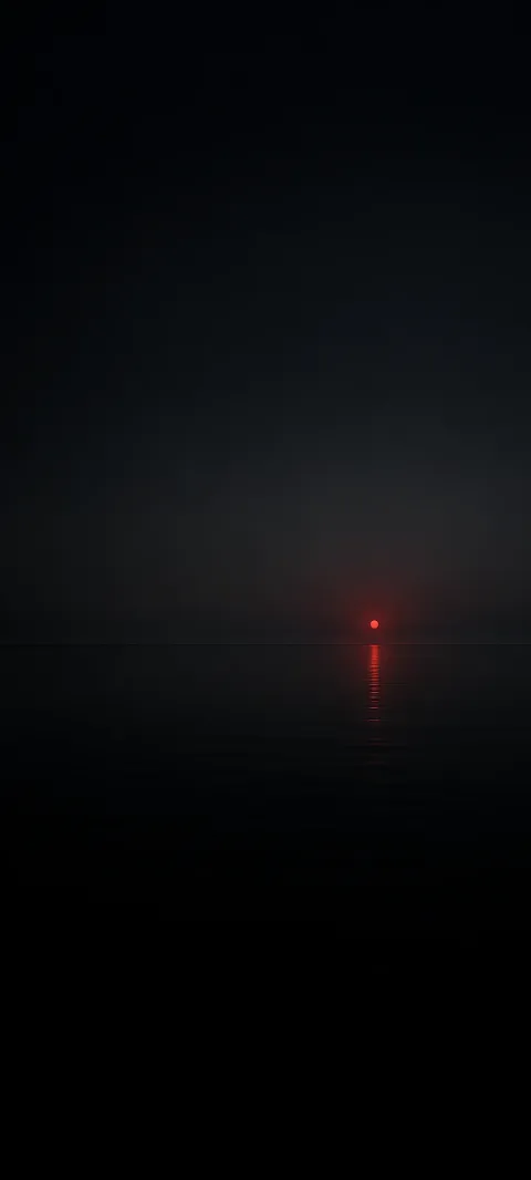 Small red light point above a dark horizon with a narrow red reflection.