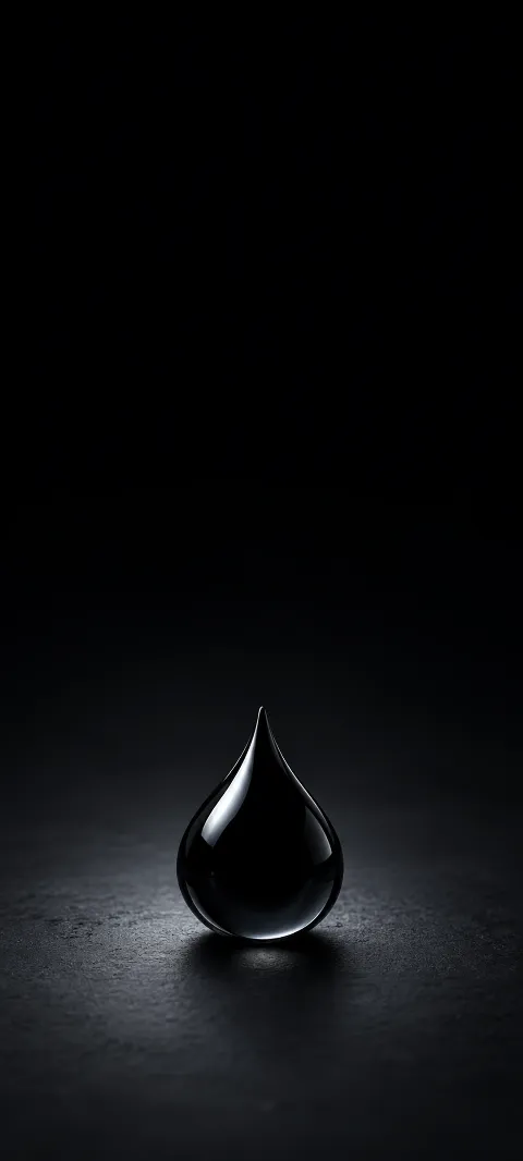 A black glass teardrop on charcoal with cool reflections and a grounded shadow.