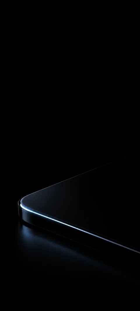 A faint icy-blue highlight traces a rounded black glass edge in darkness.