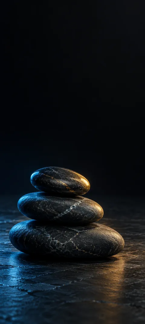 Three stacked dark slate stones with blue and gold edge light.