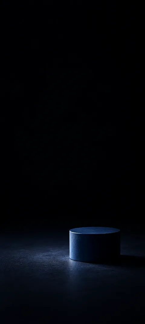 Small low dark-blue cylinder on a nearly black floor.