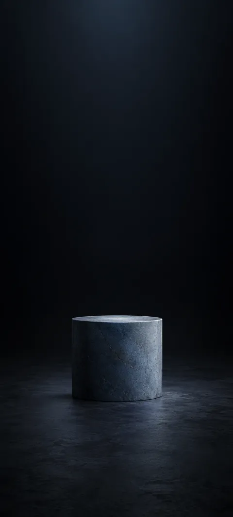 A low blue-gray pillar rises from a dark floor.