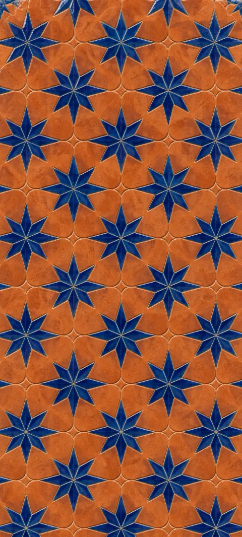 Cobalt star shapes repeat across warm terracotta ceramic.