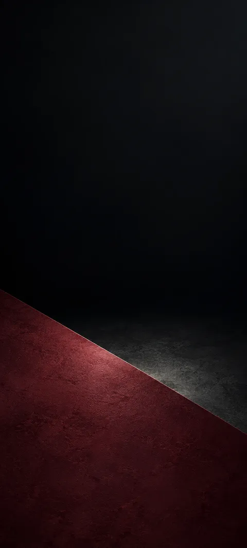 A textured burgundy plane meeting charcoal black along one diagonal edge.