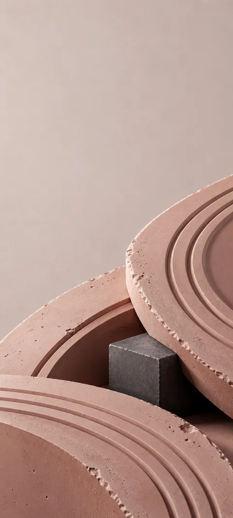 Grooved dusty rose plaster curves around a charcoal cube.