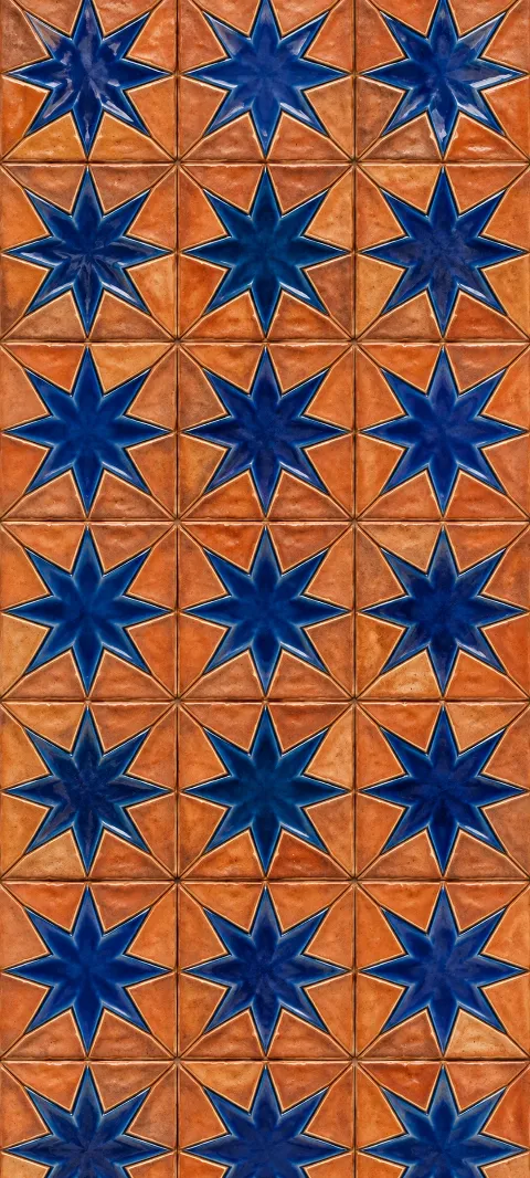 Cobalt star shapes repeat across warm terracotta ceramic.