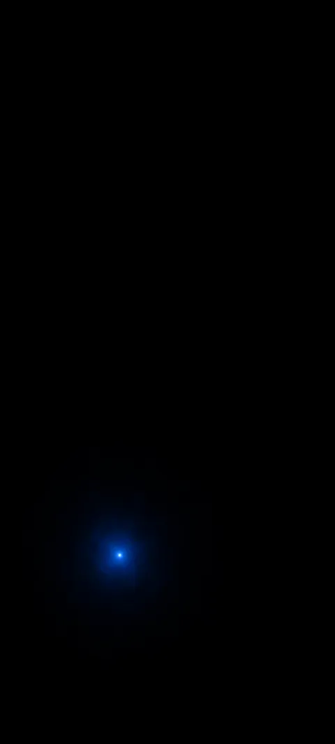 Tiny blue point with a faint glow against a broad black field.