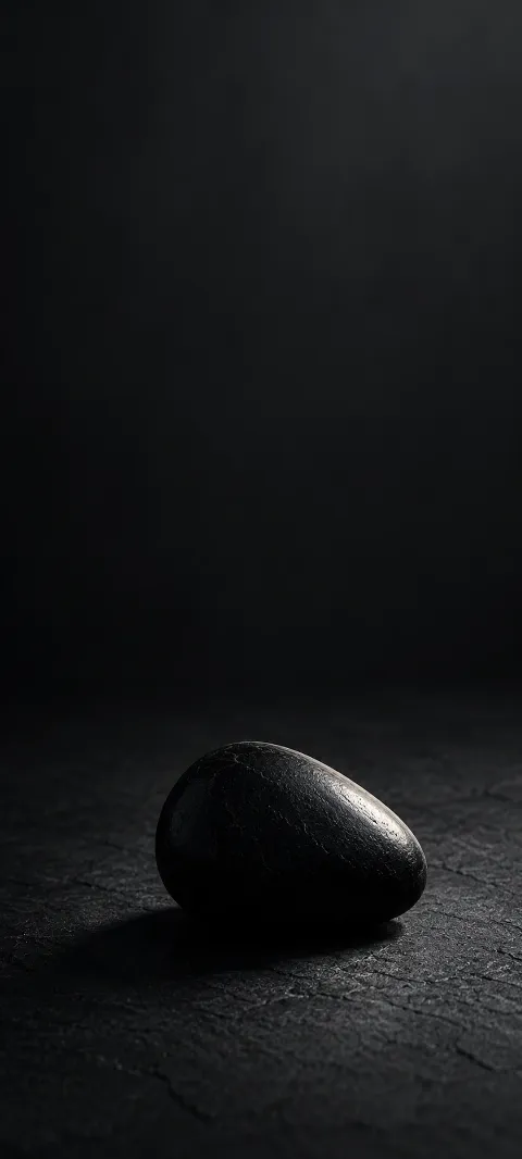 A black stone form catches one narrow highlight.
